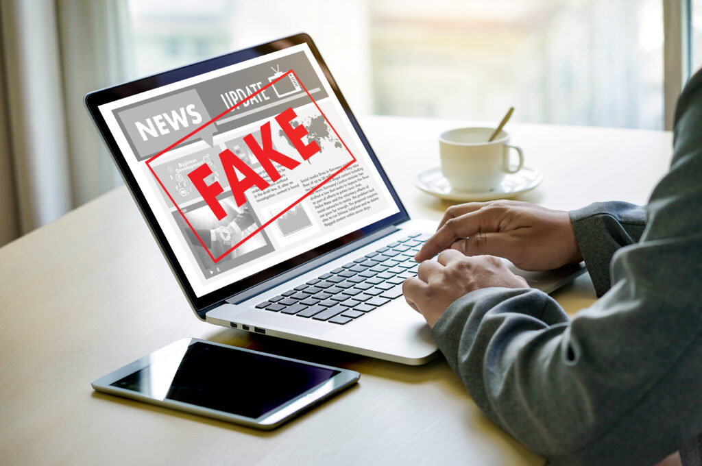 fake news - man reading fake news on laptop