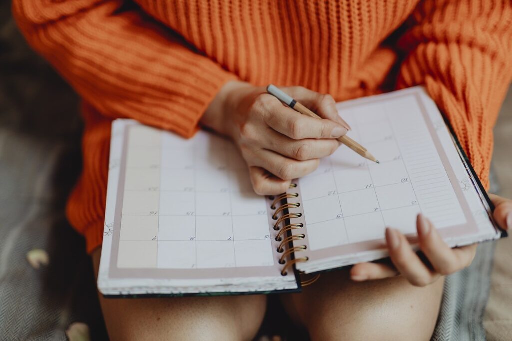 Frau trägt Termin in den Kalender