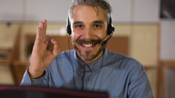 happy call center operator looking at camera and showing ok sign