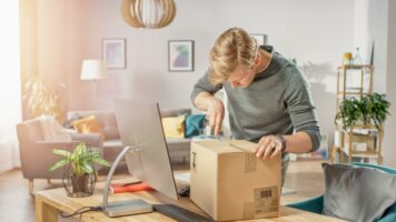 man packing box living room